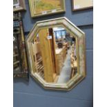 An octagonal mirror with floral and gold border