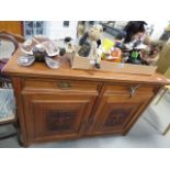 A sideboard with 2 drawers and 2 doors under, with carved panels