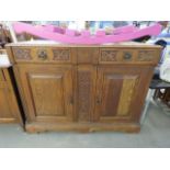 An oak sideboard with carved panels