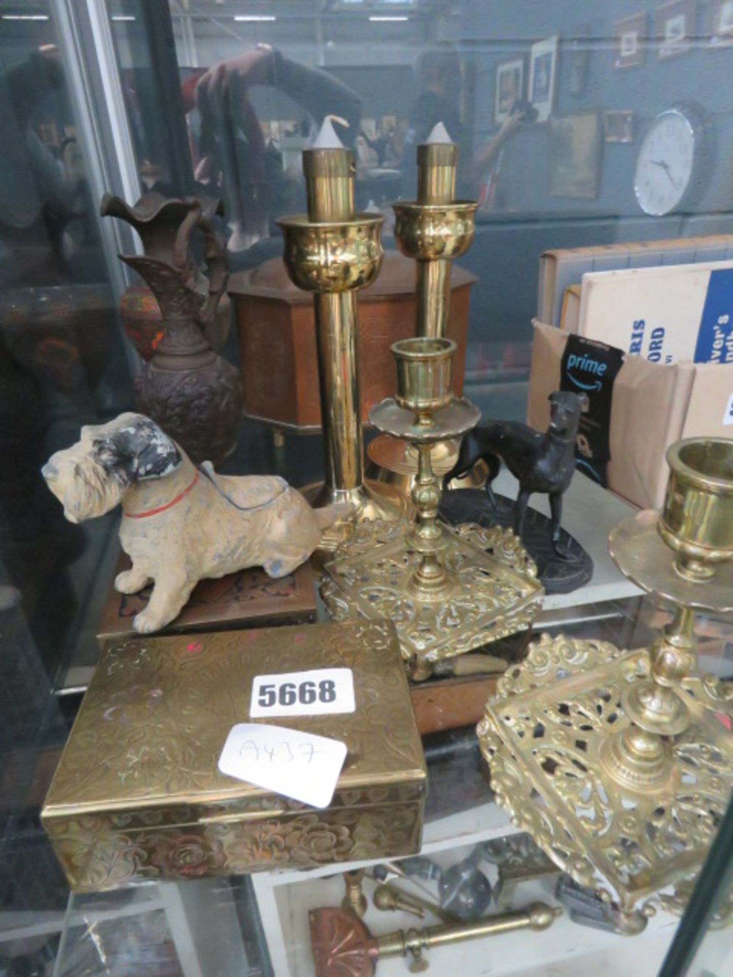 A cage containing brass candlesticks, ornamental dogs, pots and vase