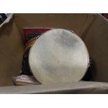 A box containing tambourine, drum sticks and musical instruments