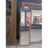 A narrow mirror in pine frame