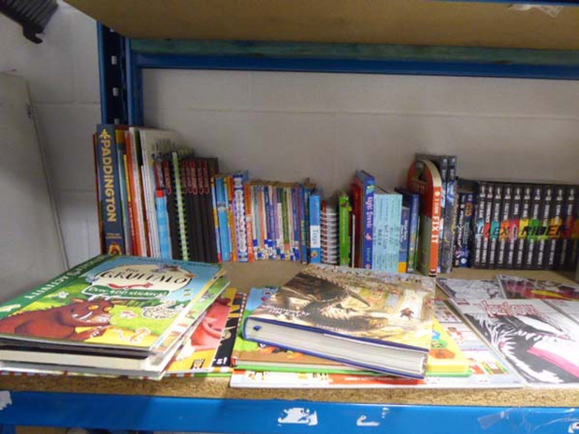 Shelf comprising of selection of children's books, puzzle books, graphic novels, comic books etc