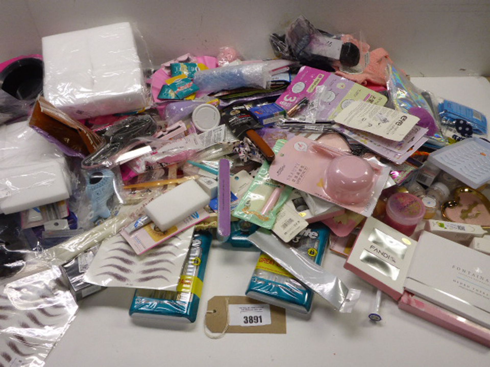 Large bag of assorted beauty products including razors, hair extensions, false eyelashes, hair