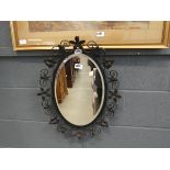 Oval bevelled mirror in black wrought iron frame