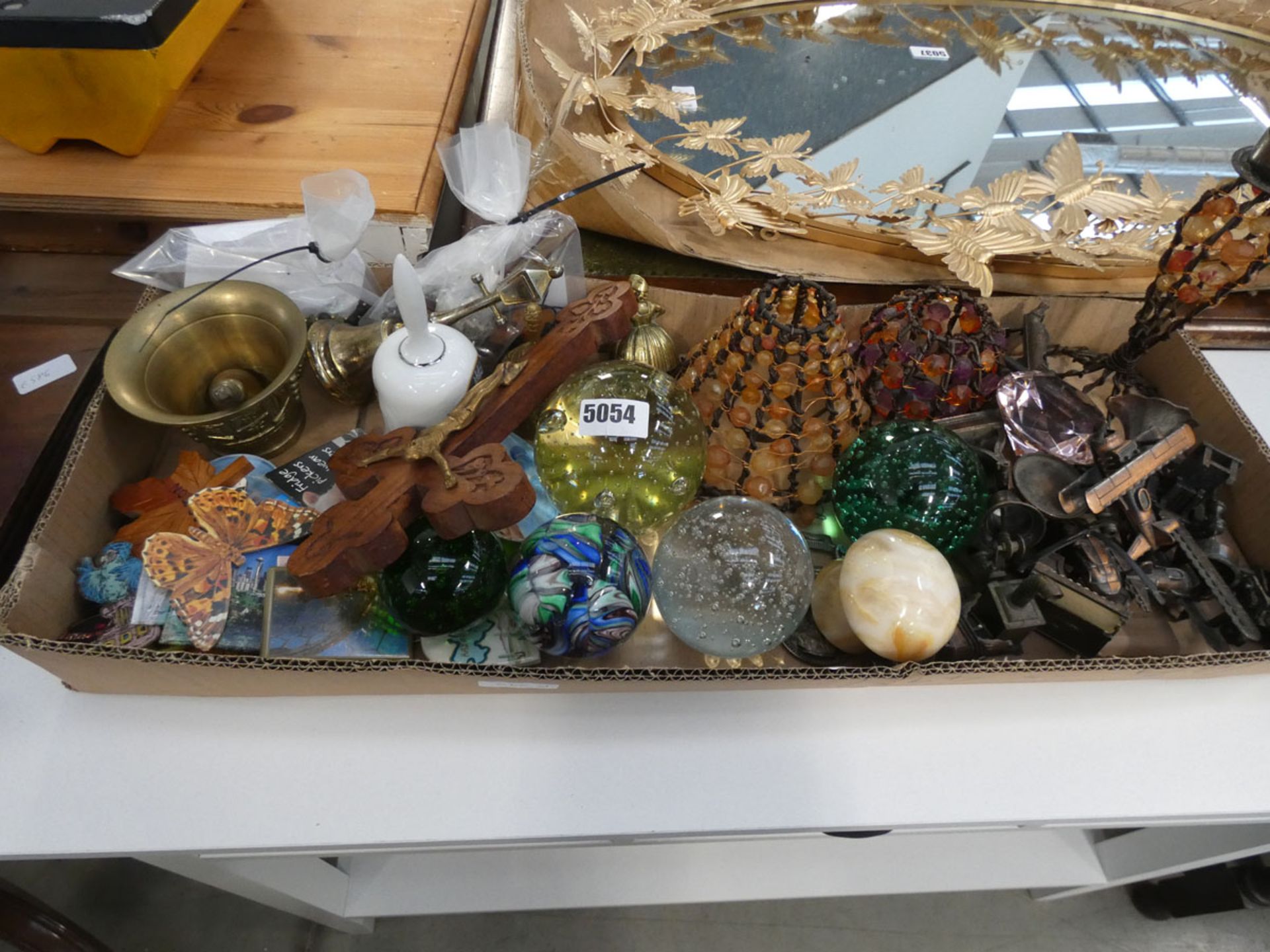 Box containing paperweights, ornamental aeroplanes, lampshades, and brassware