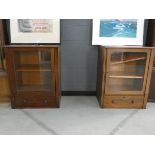 Pair of glazed single door Victorian cabinets with storage drawers under