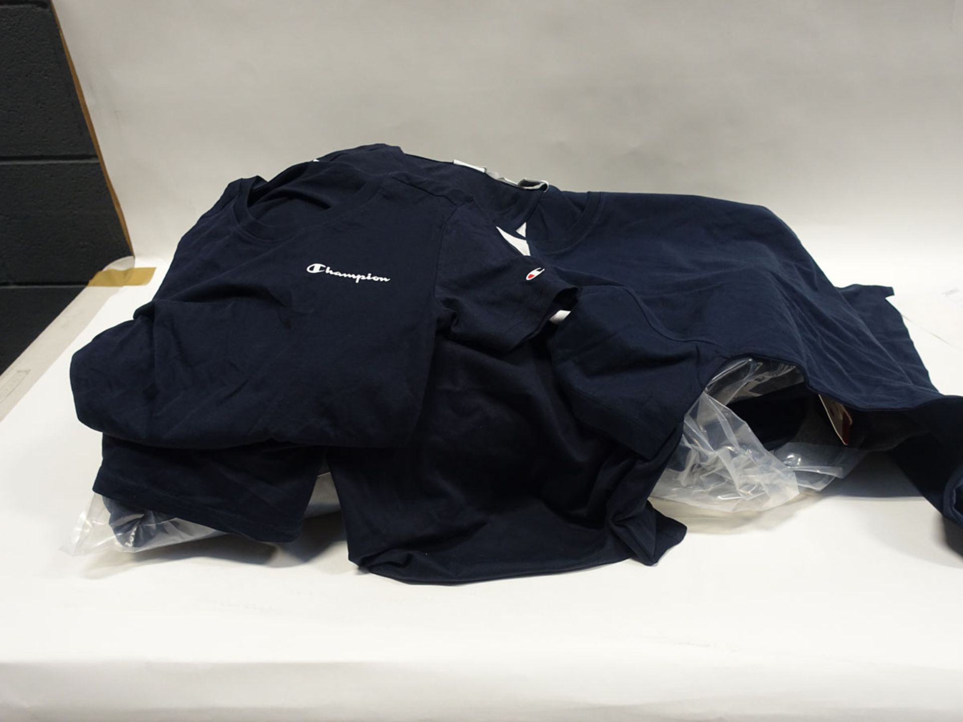 Bag containing Champion t-shirts in dark blue (various sizes)