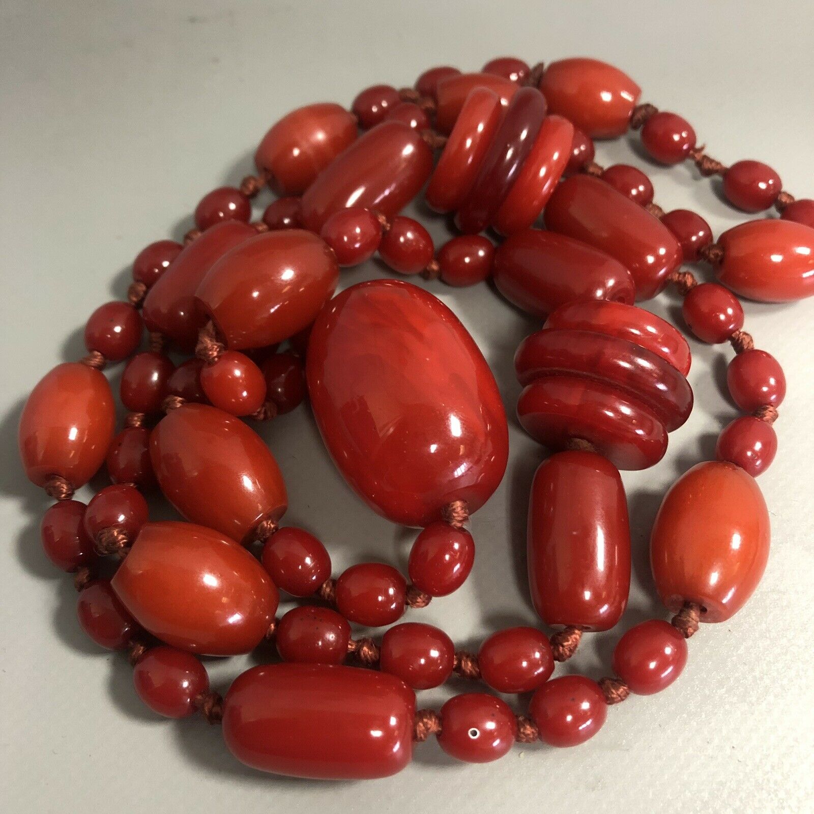 An Art Deco period long plastic necklace of chunky red beads on hand knotted string