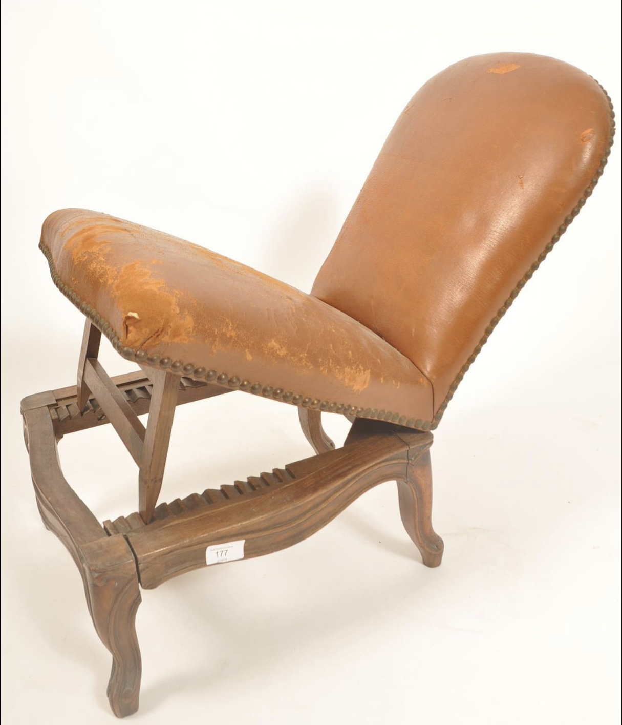 A 19th century oak and leather gout stool in the form of a French fauteuil.