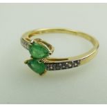 A 10ct gold, emerald and white topaz Crossover Ring, boxed