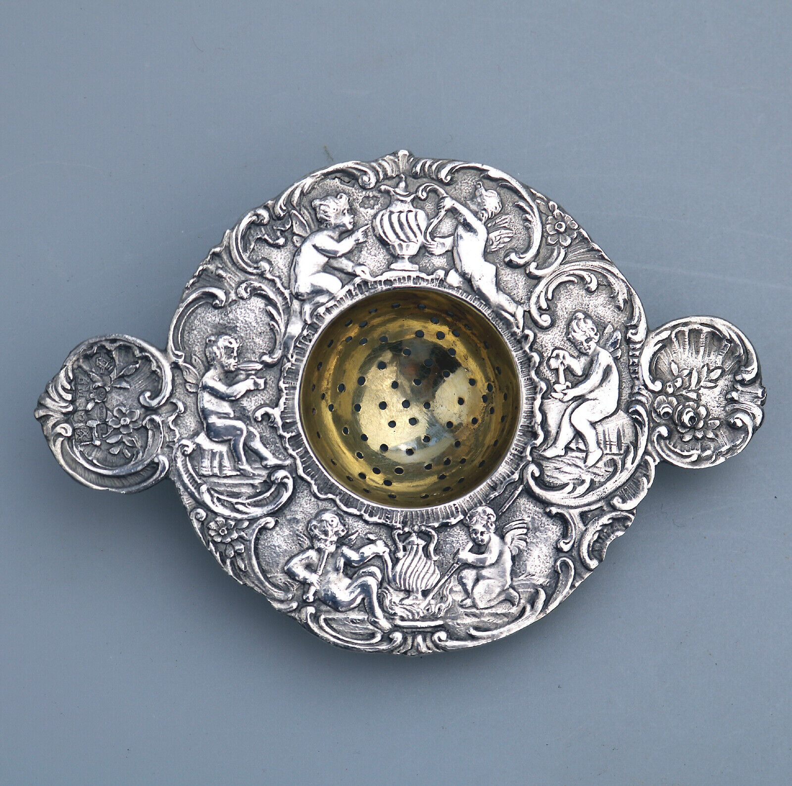 A Fine Hanau 925 Solid Silver Tea Strainer by Berthold Mueller decorated with fairies C.1906