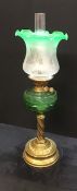 A Victorian oil lamp with green glass reservoir