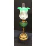 A Victorian oil lamp with green glass reservoir