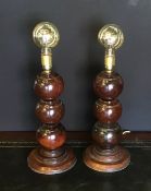 A pair of table lamps made from lignum vitae bowls on a turned oak base.