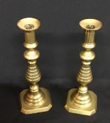 A pair of antique brass candlesticks.