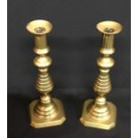 A pair of antique brass candlesticks.