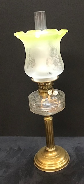 A Victorian oil lamp with a clear glass reservoir