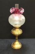 An antique Victorian oil lamp with Cranberry glass shade