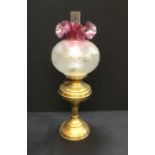 An antique Victorian oil lamp with Cranberry glass shade