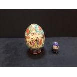 An antique moriage handpainted porcelain egg and a small closionne enamel on stand