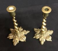 A pair of small antique brass candlesticks with barley twist stems.