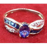 Yellow Metal Oval Tanzanite & Diamond Crossover Style Ring