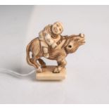 Elfenbein-Netsuke (Provenienz wohl Japan, Alter unbekannt), Mann wohl auf einem Büffelsitzend, auf