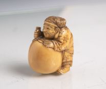 Elfenbein-Netsuke (Provenienz wohl Japan, Alter unbekannt), stehender Mann im Kimono eineKugel