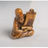 Elfenbein-Netsuke (Provenienz wohl Japan, Alter unbekannt), hockender Mann mit den Händenaufgerollte