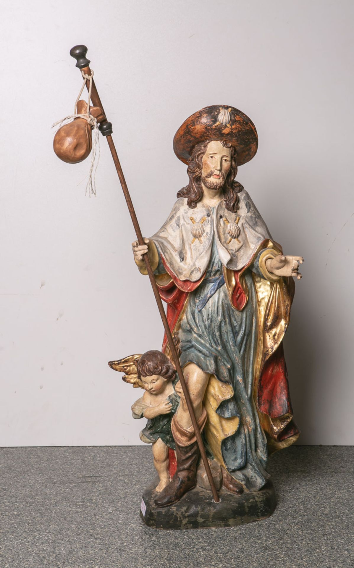 Holzfigur des Heiligen Jakobs mit Wanderstab (20. Jahrhundert), ein kleiner Engel zuseinen Füßen,