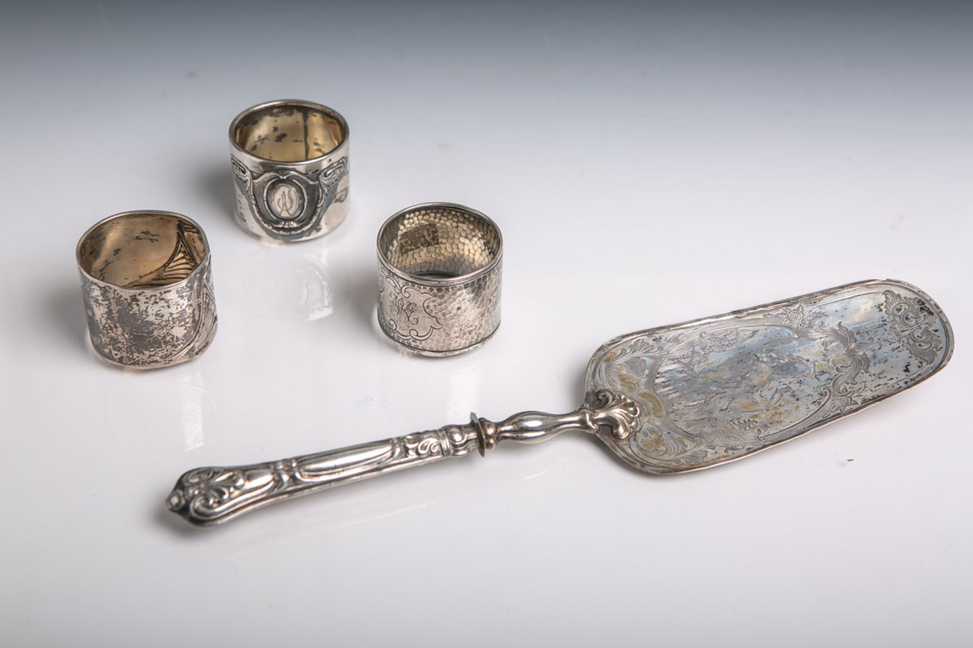 Drei diverse Serviettenringe und ein Tortenheber aus Silber (Punzierungen teils Grimminger