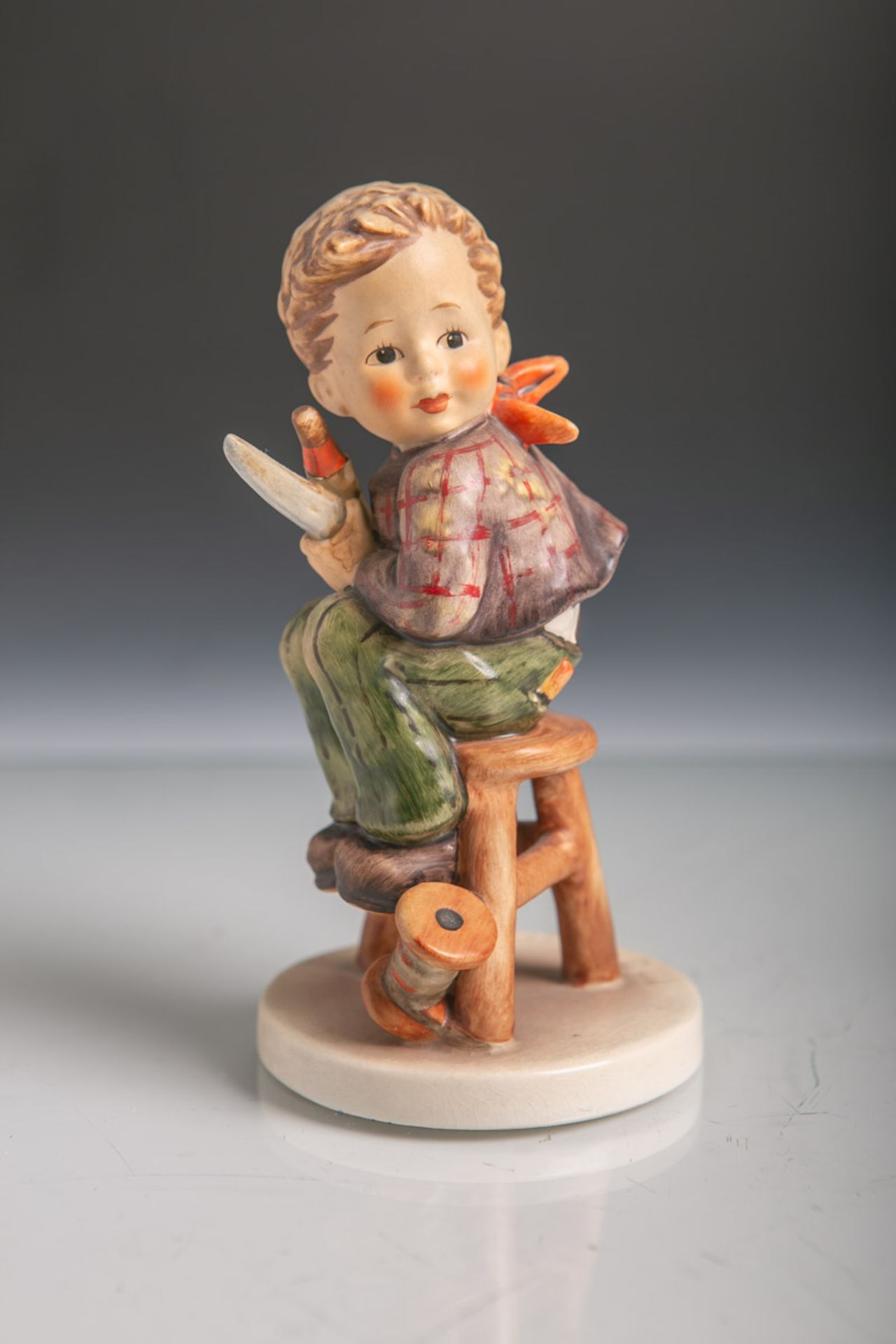 Sitzender Knabe mit Garnrolle, Fingerhut und Schere (Hummelfigur) aus Keramik von Goebel