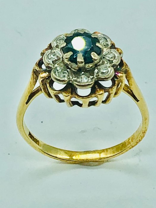 An 18ct yellow gold ring, centre claw set 5mm round sapphire with eight illusion set diamonds. - Image 2 of 10