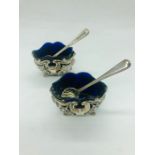 A pair of silver and blue glass salts with spoons