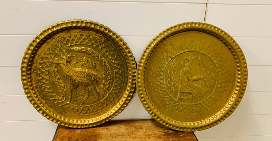A pair of brass wall plates depicting deer