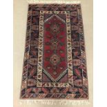 A blue and red patterned Turkish rug measuring 213cm x 120cm