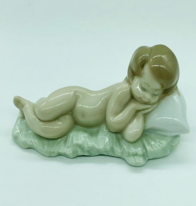 A Lladro figure of a child sleeping