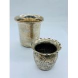 Two silver beakers or pots.