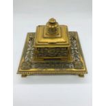 A brass inkwell with glass liner
