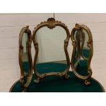 A giltwood dressing table mirror on scrolled feet