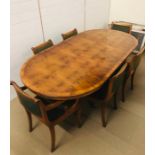 A Large extendable circular to oval dining table in a burr walnut finish with two extra leaves on