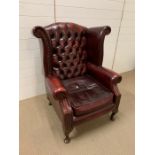 A red leather button back Chesterfield style armchair
