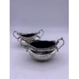 A pair of hallmarked silver salts with blue glass liners.