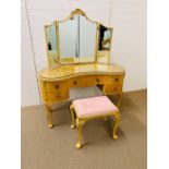 A kidney shaped five drawer dressing table with mirror and stool