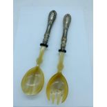 A pair of silver handled salad servers, marked 800.