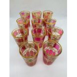 Eleven Victorian style cranberry glass tumblers with gold rim