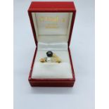 An 18ct gold ring in a rope style with a single black and white pearl with inset diamonds. size Q