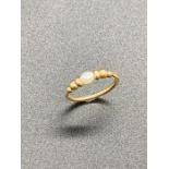 A yellow gold and seed pearl ring.