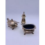 A silver hallmarked salt with blue glass liner, mustard with blue glass liner and a pepper pot.